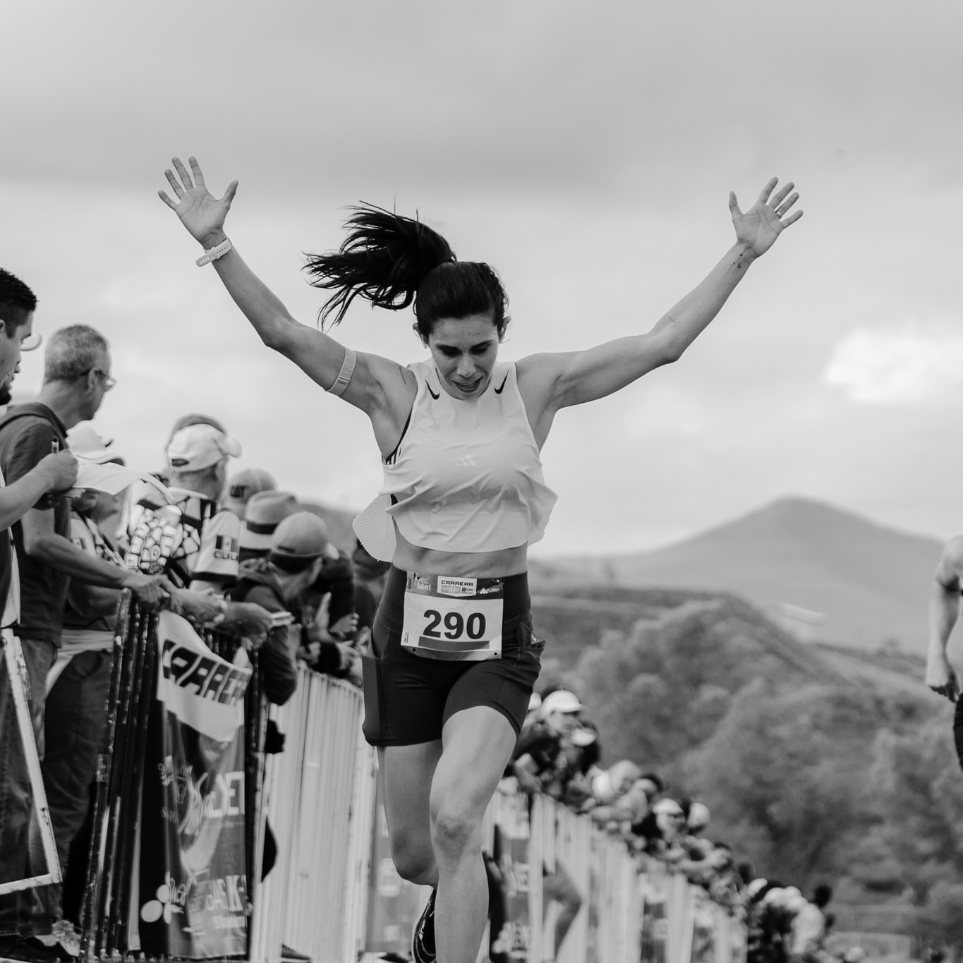 Atleta cruzando la meta con brazos en alto